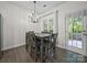 An inviting dining area with dark hardwood floors, large windows, and a stylish chandelier at 216 Devon Forest Dr, Mooresville, NC 28115