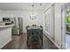 A sunny dining area features stainless steel appliances, dark floors, a chandelier, and natural light at 216 Devon Forest Dr, Mooresville, NC 28115