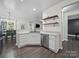 Bright, open kitchen featuring white cabinetry, stainless steel appliances, and stylish shelving, flowing into dining area at 216 Devon Forest Dr, Mooresville, NC 28115