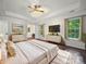 Bright main bedroom with tray ceiling, dark hardwood floors, ensuite bath access, and modern decor at 216 Devon Forest Dr, Mooresville, NC 28115