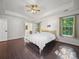 Spacious bedroom featuring dark hardwood floors, tray ceiling, and bright windows at 216 Devon Forest Dr, Mooresville, NC 28115