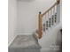 Carpeted staircase features neutral-toned walls and carpet, and natural wood accents at 216 Devon Forest Dr, Mooresville, NC 28115