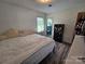 Bedroom with a view into the adjoining bathroom, wood-look flooring, and warm decor at 3546 Kershaw Camden Hwy, Lancaster, SC 29720