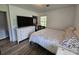 Bright bedroom featuring wood flooring, a white dresser, and a large television at 3546 Kershaw Camden Hwy, Lancaster, SC 29720
