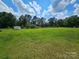 Lush green yard with a storage shed surrounded by mature trees, offering ample outdoor space at 3546 Kershaw Camden Hwy, Lancaster, SC 29720