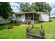 Charming backyard with a screened porch, garden bed, and mature trees providing ample shade at 357 N Main St, Mount Pleasant, NC 28124