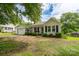 Charming single-story home featuring a quaint front porch and an attached garage on a sunny day at 357 N Main St, Mount Pleasant, NC 28124