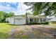 Exterior view of home featuring a detached garage and well-manicured front yard with mature shrubbery at 357 N Main St, Mount Pleasant, NC 28124