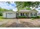 Exterior view of a white single-story house featuring an attached garage and a welcoming front porch at 357 N Main St, Mount Pleasant, NC 28124
