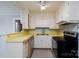 The kitchen features white cabinets, yellow countertops and black appliances at 357 N Main St, Mount Pleasant, NC 28124