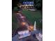 Outdoor area with ambient lighting leading to a tiered backyard with a patio area with a seating area at 369 Skyland Ct, Mount Gilead, NC 27306