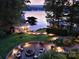 Inviting backyard with a stone patio, fire pit, and scenic lake views at sunset at 369 Skyland Ct, Mount Gilead, NC 27306