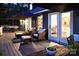 Outdoor patio with comfortable lounge chairs, decorative umbrellas, and lush landscaping at twilight at 369 Skyland Ct, Mount Gilead, NC 27306