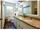 Bright bathroom with double sinks, granite countertops, white cabinets, and a large mirror at 369 Skyland Ct, Mount Gilead, NC 27306