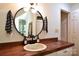 Well-lit bathroom with a rustic wooden countertop, vessel sink, round mirror, and neutral wall color at 369 Skyland Ct, Mount Gilead, NC 27306