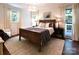 Sunlit bedroom with a wooden bed frame, neutral bedding, and access to an outdoor balcony at 369 Skyland Ct, Mount Gilead, NC 27306