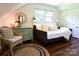 Inviting bedroom with a daybed, wicker chair, hardwood floors, and natural light from a window at 369 Skyland Ct, Mount Gilead, NC 27306