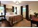 Comfortable bedroom with a metal frame bed, plush pillows, hardwood floors, and natural light from two windows at 369 Skyland Ct, Mount Gilead, NC 27306