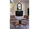 Cozy sitting area with a painted brick fireplace, decorative mirror, and unique accent chairs at 369 Skyland Ct, Mount Gilead, NC 27306