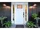 Elegant front entrance with a stylish white door, sidelights, and decorative plants at 369 Skyland Ct, Mount Gilead, NC 27306