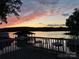 Serene lake view at sunset, showcasing a dock, boathouse, and tranquil waters at 369 Skyland Ct, Mount Gilead, NC 27306
