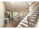 Open-concept living room with a cozy fireplace, hardwood floors, and a staircase leading to the upper level at 398 Hampton Trail Dr # 97, Fort Mill, SC 29708