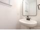 Clean powder room featuring a pedestal sink, modern faucet, and a sleek mirror at 4021 Jenison Valley Ct, Charlotte, NC 28214