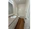 Well-lit bathroom with a single vanity, toilet, and a shower-tub combo, all enhanced by wood-look floors at 40287 Palmerville Rd, New London, NC 28127