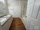 Bathroom featuring double sinks, white cabinets, and a shower with glass doors with great lighting and trim at 40287 Palmerville Rd, New London, NC 28127