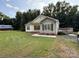 Charming home featuring a lush lawn, complemented by mature trees and a rustic outbuilding in the background at 40287 Palmerville Rd, New London, NC 28127