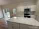 Kitchen with marble countertop island, stainless microwave, black oven, white cabinets, and sliding door to deck at 40287 Palmerville Rd, New London, NC 28127