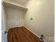 Clean laundry room with a white door, practical shelving, and wood-look flooring at 40287 Palmerville Rd, New London, NC 28127