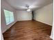 Open living room featuring hardwood floors, a ceiling fan, crown molding, and large windows providing natural light at 40287 Palmerville Rd, New London, NC 28127