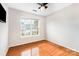 Bright bedroom features hardwood floors, a ceiling fan, and a large window providing ample natural light at 409 Lexie Ln, Rock Hill, SC 29732