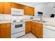Functional kitchen features wooden cabinets, white appliances, and a practical layout at 409 Lexie Ln, Rock Hill, SC 29732