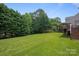 Expansive backyard with lush green lawn, mature trees, and a wooden deck, perfect for outdoor enjoyment at 5005 Chestnut Knoll Ln, Charlotte, NC 28269