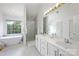 Bright bathroom with double vanity, soaking tub, glass shower, and marble flooring at 5005 Chestnut Knoll Ln, Charlotte, NC 28269