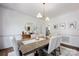 Bright dining room features hardwood floors, neutral decor, stylish lighting, and seating for six at 5005 Chestnut Knoll Ln, Charlotte, NC 28269