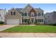 Charming two-story home with a well-manicured lawn, brick accents, black shutters, and attached garage at 5005 Chestnut Knoll Ln, Charlotte, NC 28269