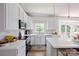 Bright kitchen features white cabinets, marble backsplash, quartz countertop, stainless steel appliances and gold hardware at 5005 Chestnut Knoll Ln, Charlotte, NC 28269