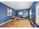 Home office with modern desk, laminate floors, blue walls, lots of natural light and comfortable seating at 5005 Chestnut Knoll Ln, Charlotte, NC 28269