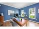 Home office featuring a modern desk, laminate floors, blue walls, natural light, and comfortable seating at 5005 Chestnut Knoll Ln, Charlotte, NC 28269