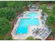 Aerial view of a large community pool with lounge chairs, umbrellas, and a clubhouse, offering a resort-style experience at 5005 Chestnut Knoll Ln, Charlotte, NC 28269