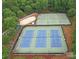 Aerial view of several well-maintained tennis courts and a sand volleyball court surrounded by lush greenery at 5005 Chestnut Knoll Ln, Charlotte, NC 28269