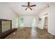 Open-concept living room with a decorative fireplace, light-colored walls, and hardwood floors at 5143 Delivau Dr, Charlotte, NC 28215