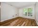 Living room with hardwood floors, a white door, and natural light streaming through large windows at 5143 Delivau Dr, Charlotte, NC 28215
