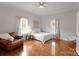 Bright bedroom with wood floors, large windows, a ceiling fan, and a cozy seating area at 515 N Main Gq St, Granite Quarry, NC 28146