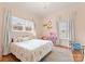 Charming bedroom with a chandelier, large windows, plush bedding, and adorable decor at 515 N Main Gq St, Granite Quarry, NC 28146