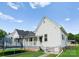 Charming white home featuring a covered porch, well-maintained yard, and bright blue skies at 515 N Main Gq St, Granite Quarry, NC 28146