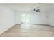 Bright, airy living room features modern ceiling fan, sliding glass doors, and light-colored hardwood flooring at 5226 Fair Wind Ln, Charlotte, NC 28212